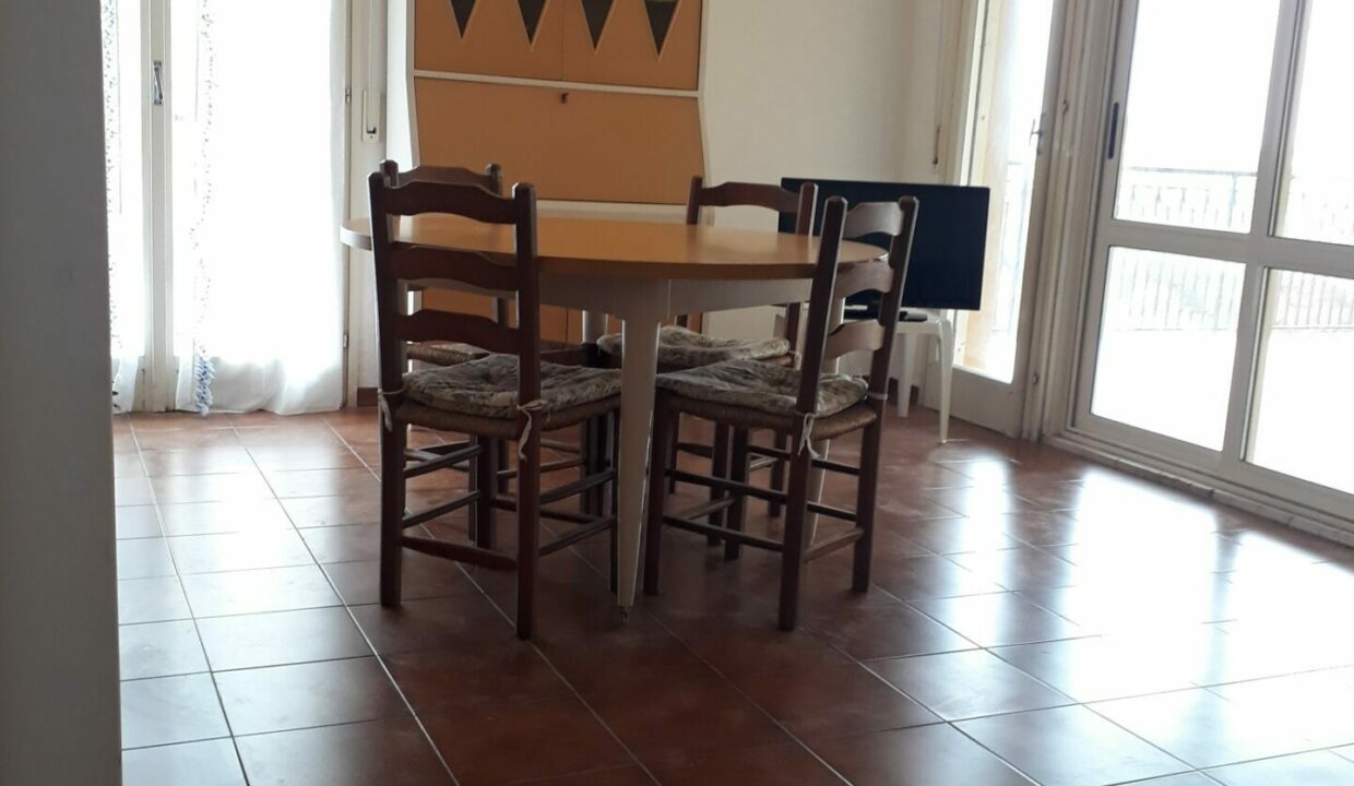Attico lungomare Lido di Classe, ampio soggiorno con tavolo e accesso terrazzo