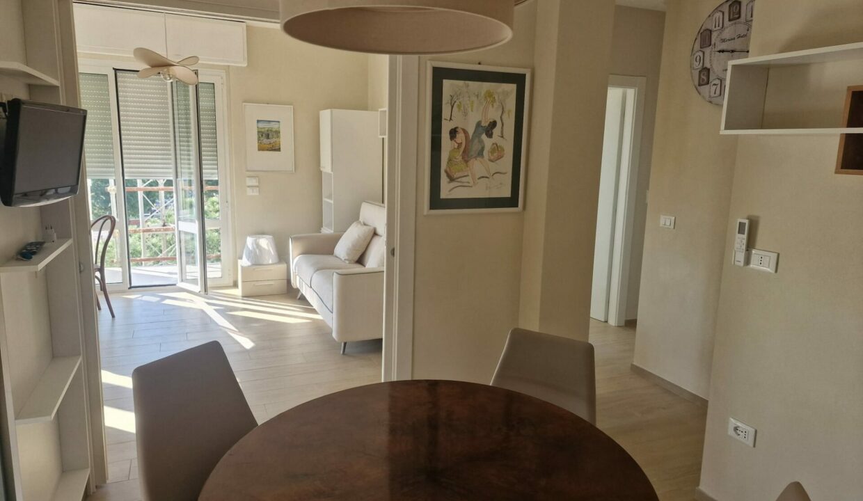 Trilocale Milano Marittima, soggiorno luminoso con tavolo rotondo e vista porto canale